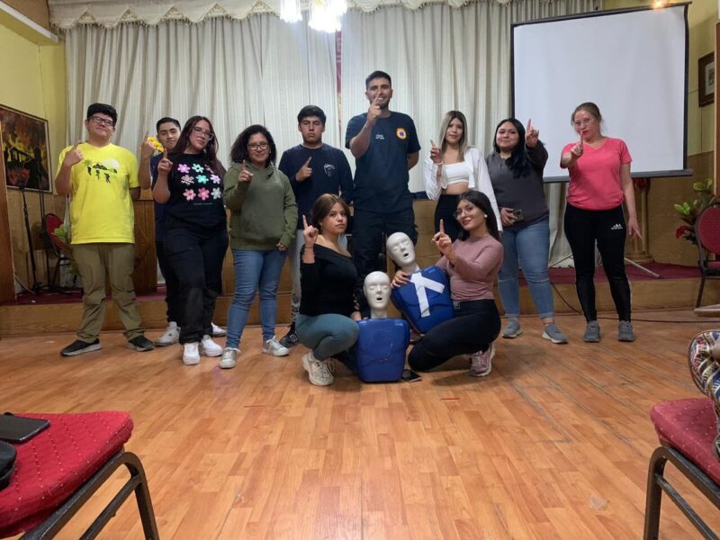 Foto de grupo de un curso, con los alumnos y los fantomas de práctica en el suelo