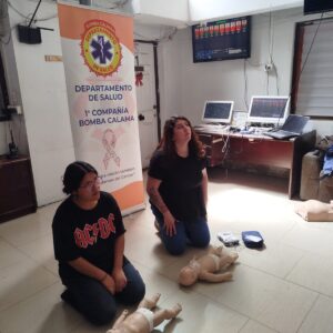 Grupo practicando RCP pediátrica con fantomas de lactante en una sala