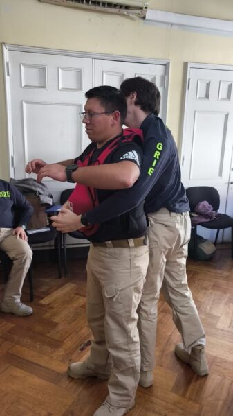 Dos personas de uniforme practicando una maniobra en una sala