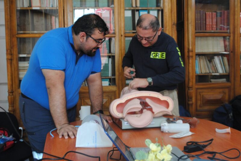 Instructores practicando con un simulador clínico sobre una mesa