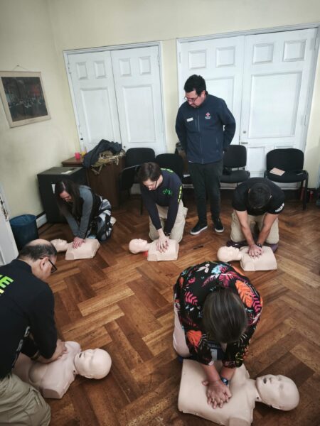 Varias personas practicando RCP con fantomas en el suelo de una sala
