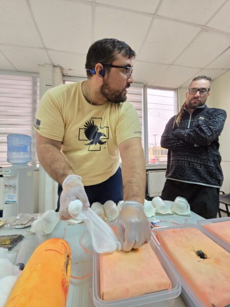 Persona empaquetando una herida simulada con gasa